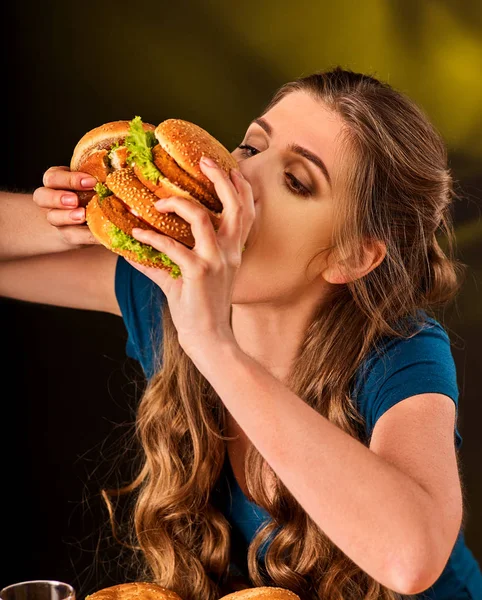 Mujer comiendo papas fritas y hamburguesa con pizza . — Foto de Stock