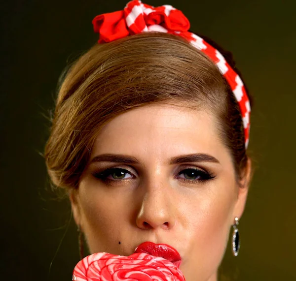 Woman eating lollipops. Girl in pin-up style hold striped candy. — Stock Photo, Image