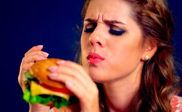 ファーストフードを食べる女。女の子楽しんでおいしいハンバーガー. — ストック写真