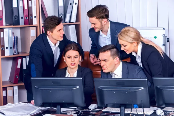 Equipe de pessoas de negócios pessoas que trabalham com papéis por monitor de computador . — Fotografia de Stock