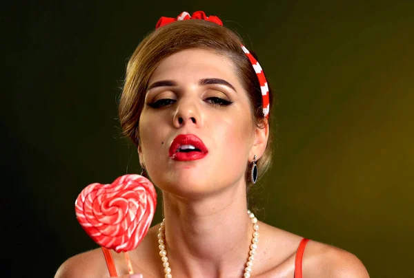 A nő evés nyalókák. Pin-up stílus lány tartsa csíkos candy. — Stock Fotó
