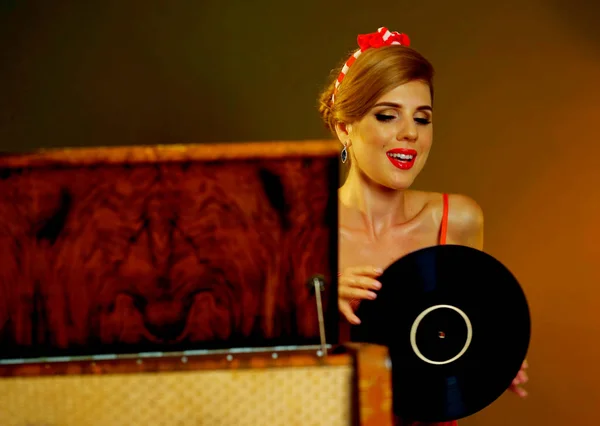 DJ retro kvinna vintage vinyl skivspelare musik. Flicka pin-up stil iklädd röd klänning. — Stockfoto