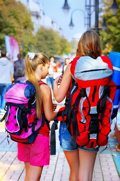 Девушки путешественницы с рюкзаком способ поиска по туристической бумажной карте — стоковое фото