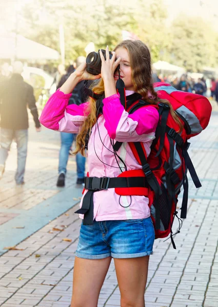 สาวนักท่องเที่ยวพร้อมกระเป๋าเป้สะพายหลัง ถ่ายรูปบนกล้อง dslr — ภาพถ่ายสต็อก