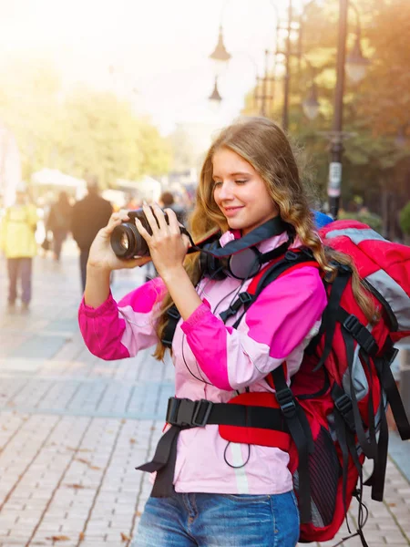 Chica turística con mochila tomando fotos en la cámara dslr —  Fotos de Stock