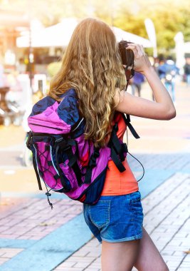 Dijital kamerada fotoğraf çekmek sırt çantası ile turist kız