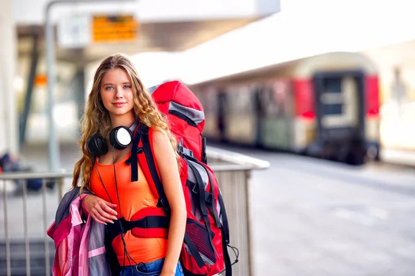 Utazó lány női hátizsák és a turizmus ruhát vasútállomáson — Stock Fotó