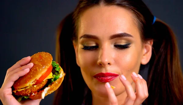 Žena jíst hamburger. Holka chce jíst fast food. — Stock fotografie