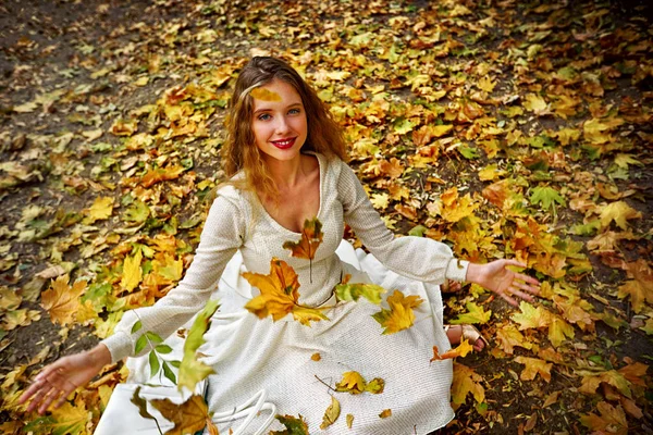 Outono vestido de moda mulher sentado queda deixa parque da cidade ao ar livre . — Fotografia de Stock