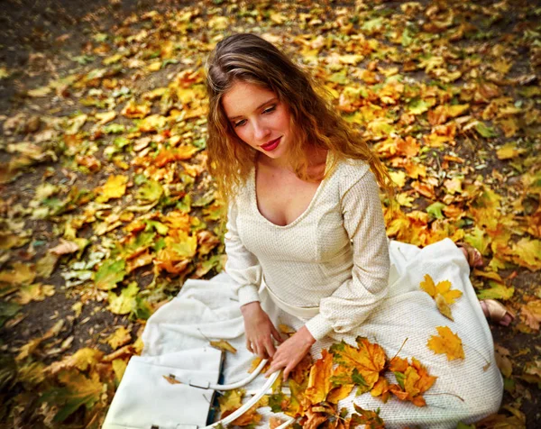 Sonbahar yaprakları Şehir Parkı açık oturan bir sonbahar moda elbise bayan. — Stok fotoğraf