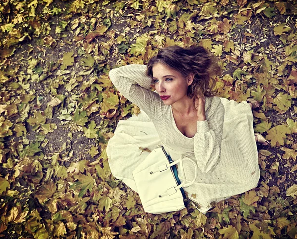 Autunno abito moda donna seduta caduta lascia parco della città all'aperto . — Foto Stock