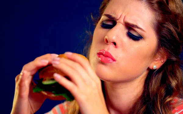 Kvinnan bett hamburgare snabbmat. — Stockfoto