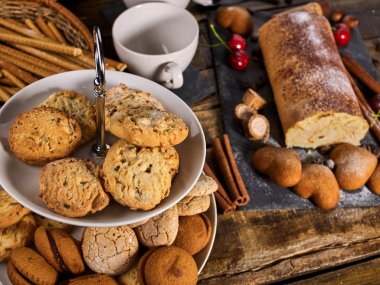Yulaf ezmeli kurabiyeler, vişneli kek standında rulo pasta.