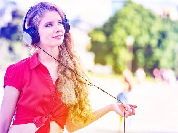 Chica en auriculares y camisa roja escucha música mp3 —  Fotos de Stock