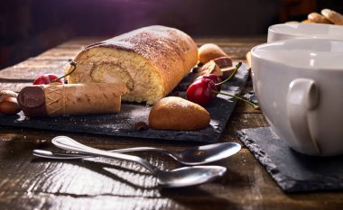 Yulaflı kurabiyeler, vişneli pasta standında haddelenmiş kek
