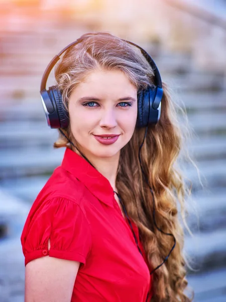 Chica en auriculares escucha música bajando escaleras —  Fotos de Stock