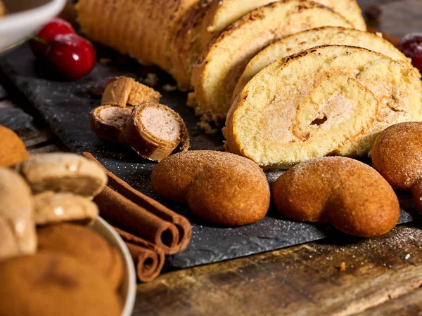 Biscuits de sable en forme de coeur, gâteau roulé avec cerise, bâton de cannelle — Photo