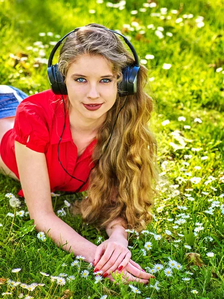 Menina em fones de ouvido pegar música ritmo na grama verde — Fotografia de Stock