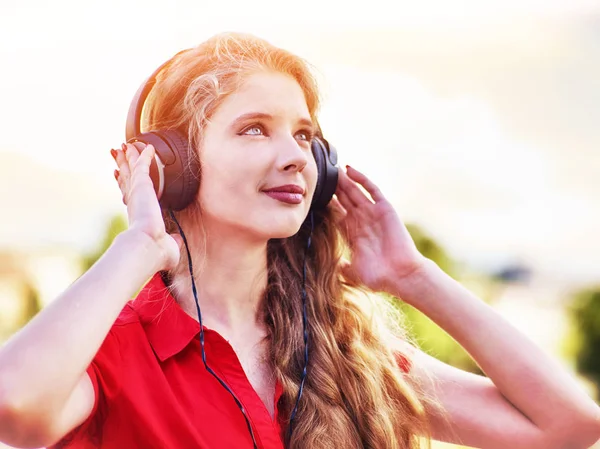 Chica en auriculares escucha música en la ciudad —  Fotos de Stock