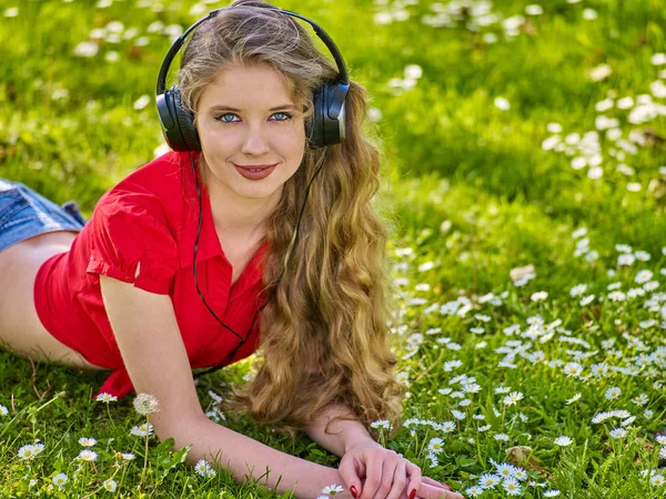 Girl in headphone catch rhythm music on green grass — Stok Foto