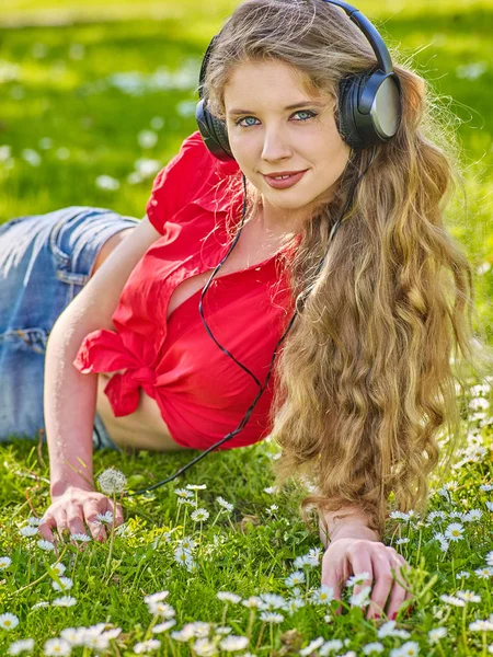 Chica en auriculares coger música ritmo en hierba verde —  Fotos de Stock