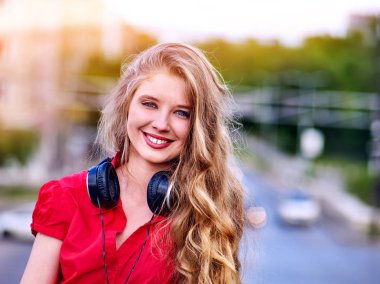 Sırt çantası kulaklık ile Öğrenci kız yeşil çim müzik dinlemek