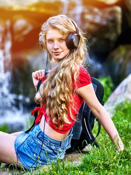 Estudiante chica con auriculares mochila escuchar música sobre hierba verde —  Fotos de Stock
