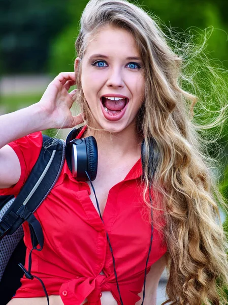 Estudiante chica con auriculares mochila escuchar música sobre hierba verde —  Fotos de Stock