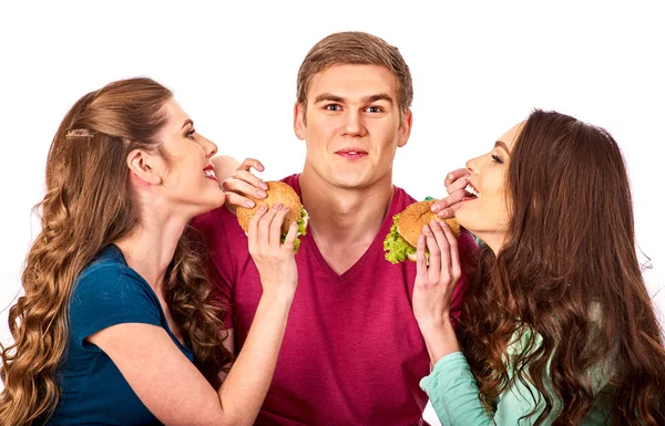 La gente del grupo come hamburguesas. Las mujeres y el hombre toman comida rápida — Foto de Stock