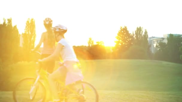 Дети в шлеме на велосипеде салют восходящего солнца в летнем парке — стоковое видео