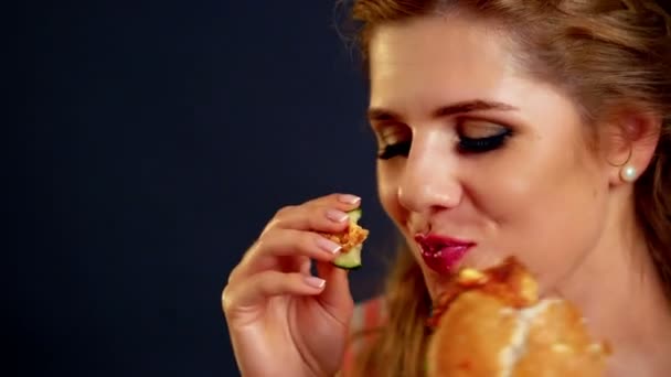 Uma rapariga a comer hambúrguer. Fast Food hambúrguer de mulher nibble flerte — Vídeo de Stock