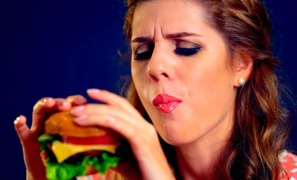 Menina em lugares de comida come hambúrguer — Fotografia de Stock