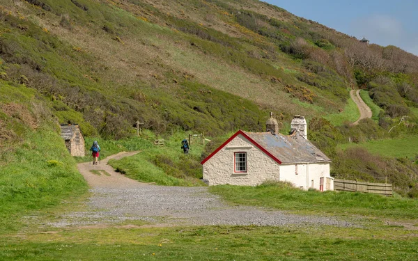 Hikers by cottage near Hartland Quay in Devon — Stock Photo, Image