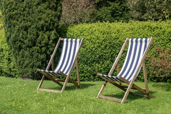 Zwei typisch englische Liegestühle auf Rasen im Garten — Stockfoto