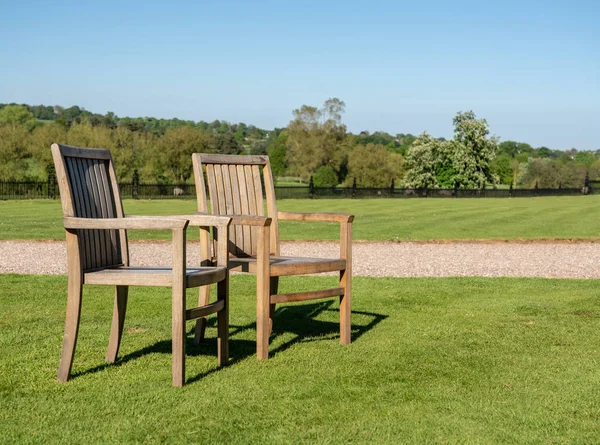 Twee teak stoelen op gazon in grote tuin — Stockfoto