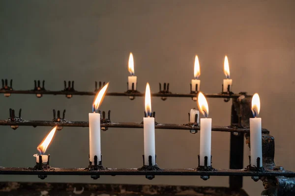 Stativ av brinnande bön ljus i gamla kyrkan — Stockfoto
