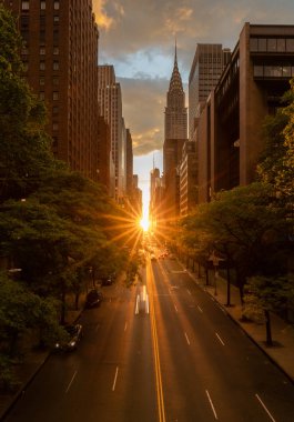 Manhattanhenge when the sun sets along 42nd street in NY clipart