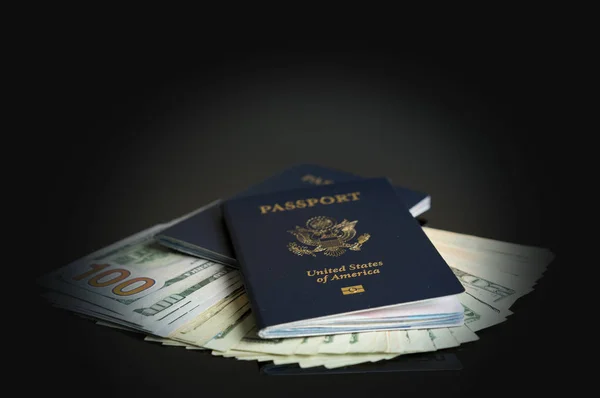 Dois passaportes dos EUA em uma pilha de notas de dólar para o conceito de viagem — Fotografia de Stock