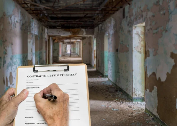 Contractor filling out estimate for abandoned office or hotel — Stock Photo, Image