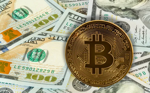 Bitcoin overlaid against 100 dollar US bills or notes — Stock Photo, Image