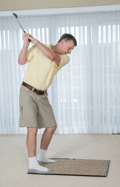Hombre adulto mayor practicando golf agarre y swing en el dormitorio — Foto de Stock