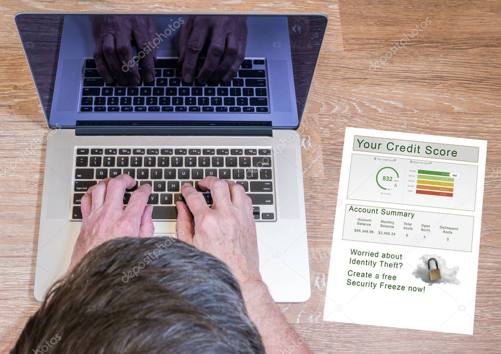 Man typing on laptop with credit report