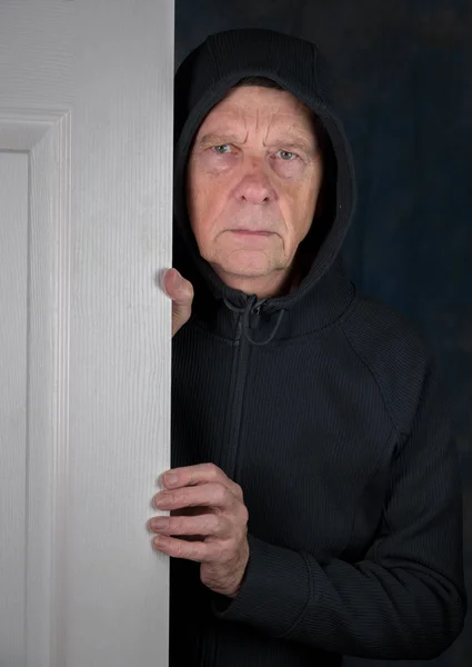 Старший білий чоловік вітає відвідувача біля дверей — стокове фото
