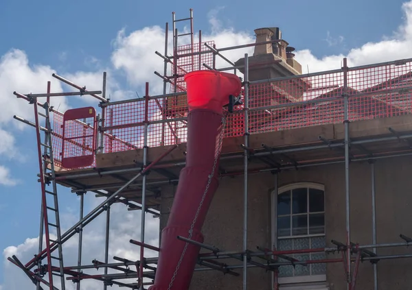 Scaffolding around roof and chimney of stone house — Stock Photo, Image