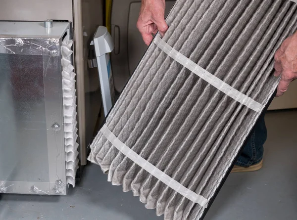 Starší muž mění špinavý vzduchový filtr v peci Hvac — Stock fotografie