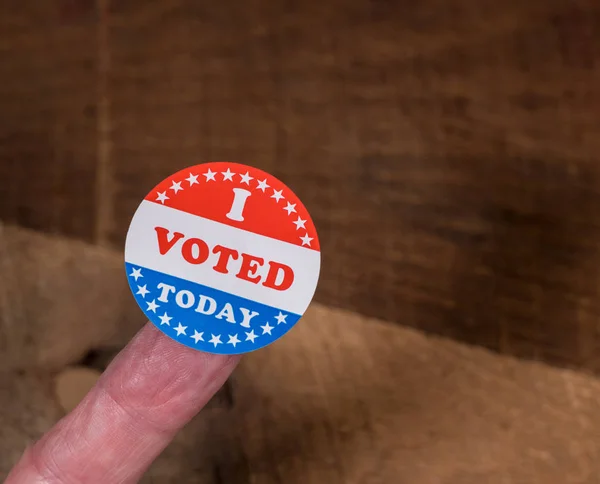 I Voted Today paper sticker on mans finger on rustic wooden table — Stock Photo, Image