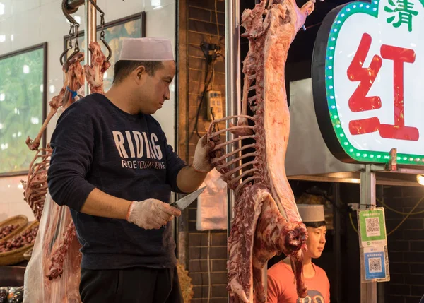 Pouliční prodavači dodavatelé v muslimské čtvrti Xian s jatečně upravených těl jehňat — Stock fotografie