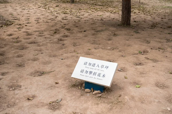 Humorystyczny znak, aby trzymać się z dala od trawnika na nagim polu ziemi — Zdjęcie stockowe