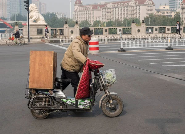 Hombre local con scooter eléctrico por RIver Haihe en Tianjin — Foto de Stock