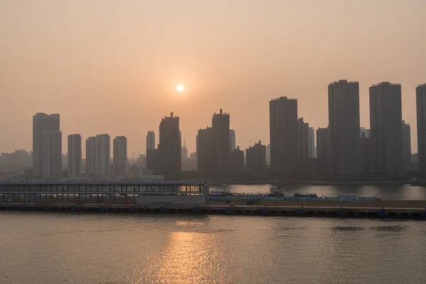 Sun rising behind the tall city skyline of Qingdao in China — Stock Photo, Image